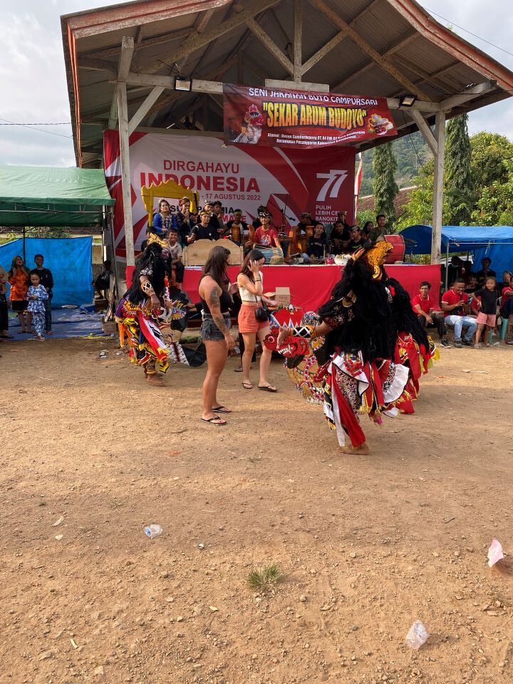 ruta por indonesia grupo de gente bailando y disfrazado mientras otros obsrevan en el exterior